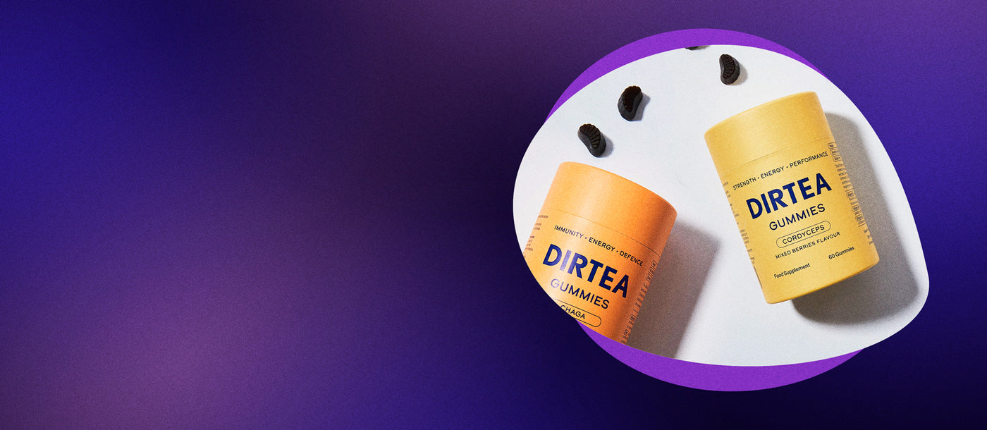 Two containers of DIRTEA Gummies on a white plate with a purple background